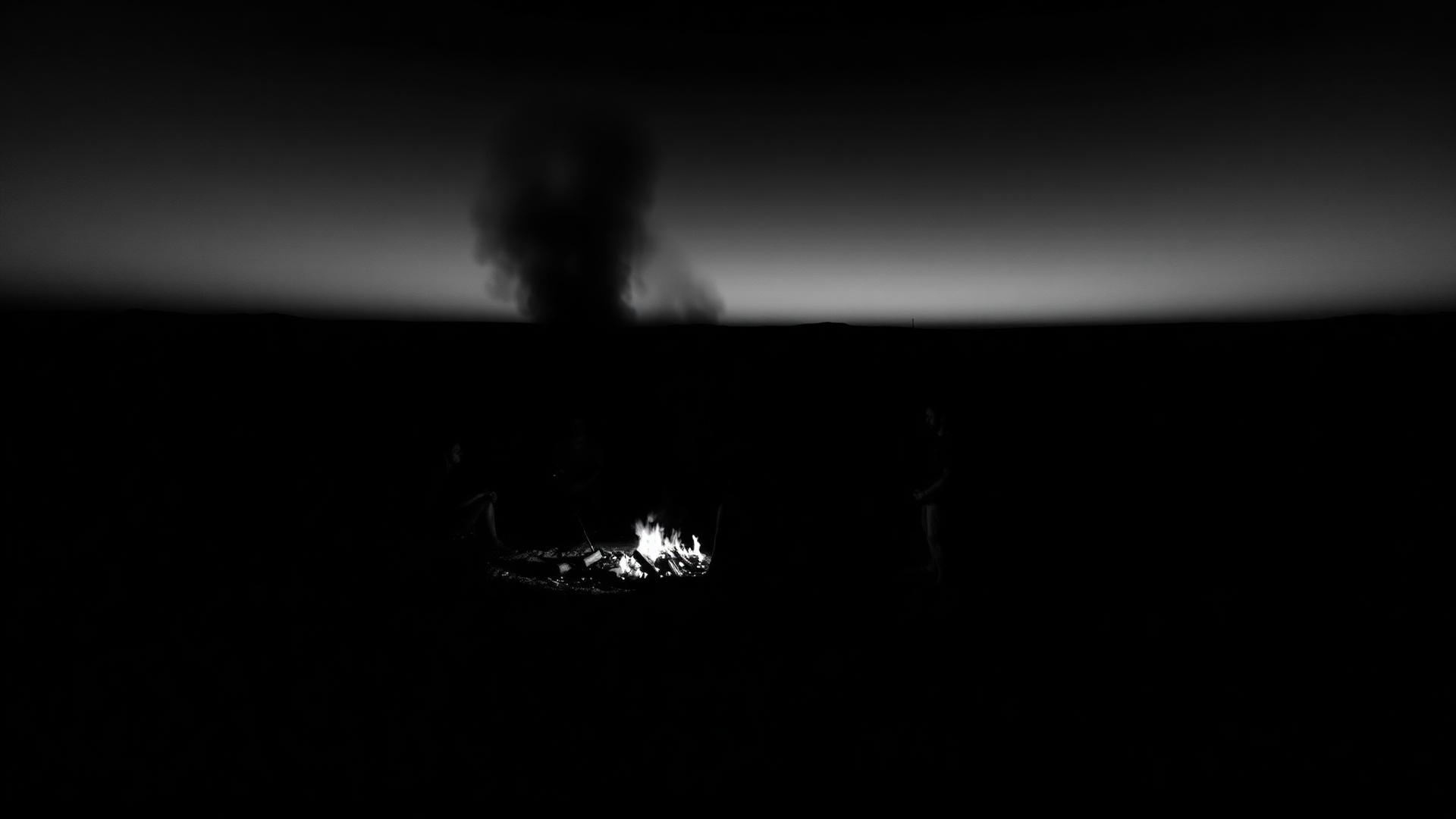 Menschen am Feuer in der Dämmerung